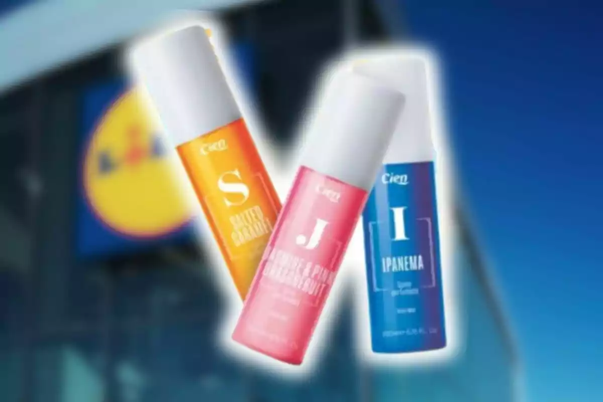Tres frascos de body mist de la marca Cien de Lidl en colores naranja, rosa y azul frente a una tienda Lidl desenfocada. Tres frascos de body mist de la marca Cien de Lidl en colores naranja, rosa y azul frente a una tienda Lidl desenfocada.