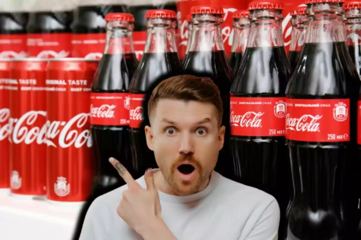 Un hombre sorprendido señala hacia un grupo de botellas y latas de refresco con etiquetas rojas.