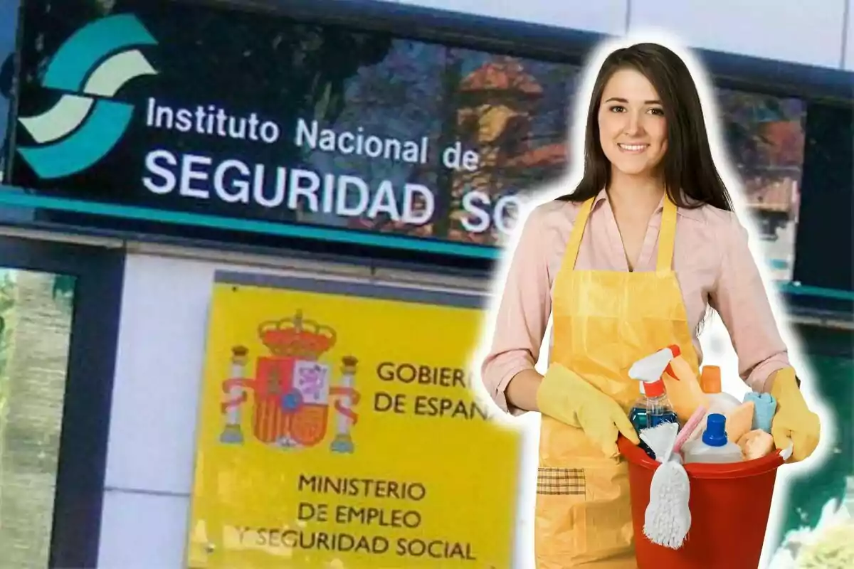 Una mujer con delantal y guantes de limpieza sostiene un balde con productos de limpieza frente a un edificio del Instituto Nacional de Seguridad Social en España.