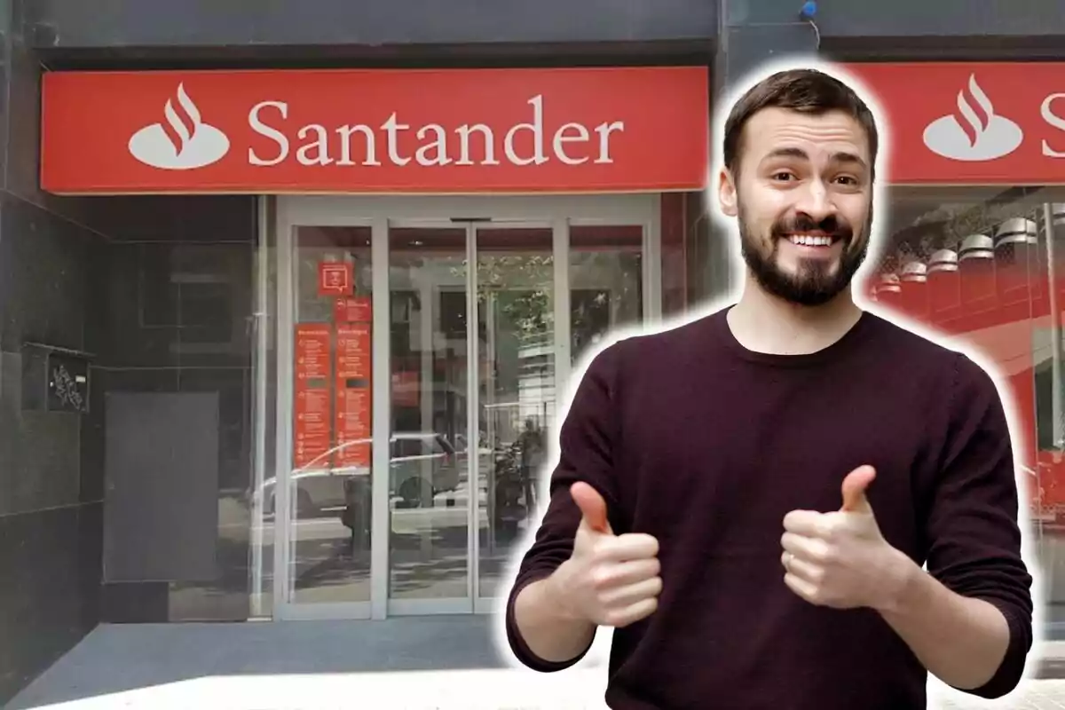 Un hombre sonriente con pulgares hacia arriba frente a una sucursal del banco Santander.