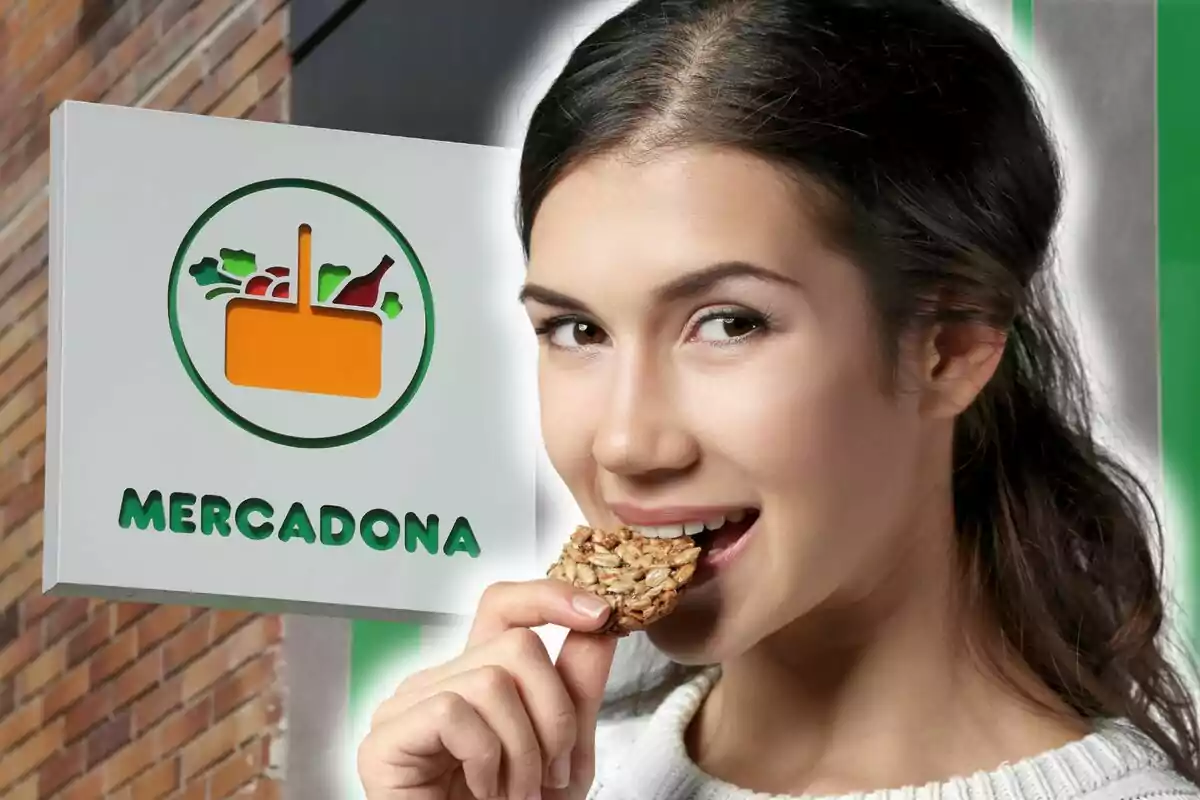 Una persona sonriente sostiene una galleta de granola frente a un cartel de Mercadona.