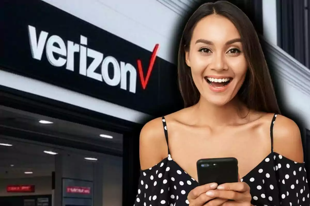 Una mujer sonriente sostiene un teléfono frente a una tienda de Verizon en Estados Unidos.