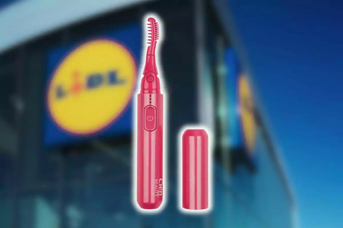 Rizador de pestañas eléctrico color rosa de Lidl con tapa junto a la fachada de una tienda Lidl desenfocada al fondo. Rizador de pestañas eléctrico color rosa de Lidl con tapa junto a la fachada de una tienda Lidl desenfocada al fondo.
