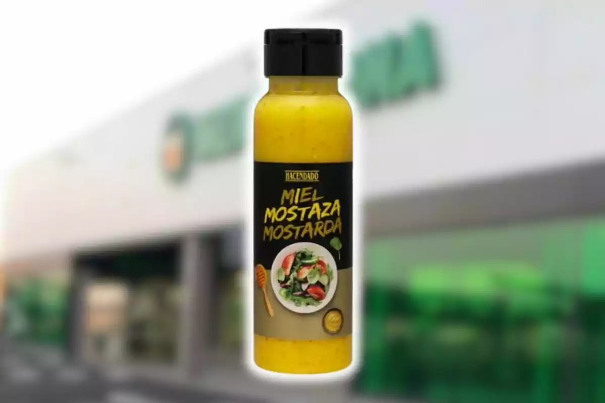 Botella de salsa de miel y mostaza de la marca Hacendado frente a un supermercado.