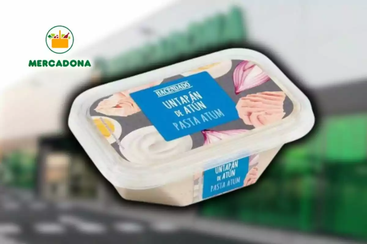 Envase de untapán de atún de la marca Hacendado con diseño de cebolla y atún en la etiqueta, frente a un fondo desenfocado de un supermercado Mercadona. Envase de untapán de atún de la marca Hacendado con diseño de cebolla y atún en la etiqueta, frente a un fondo desenfocado de un supermercado Mercadona.