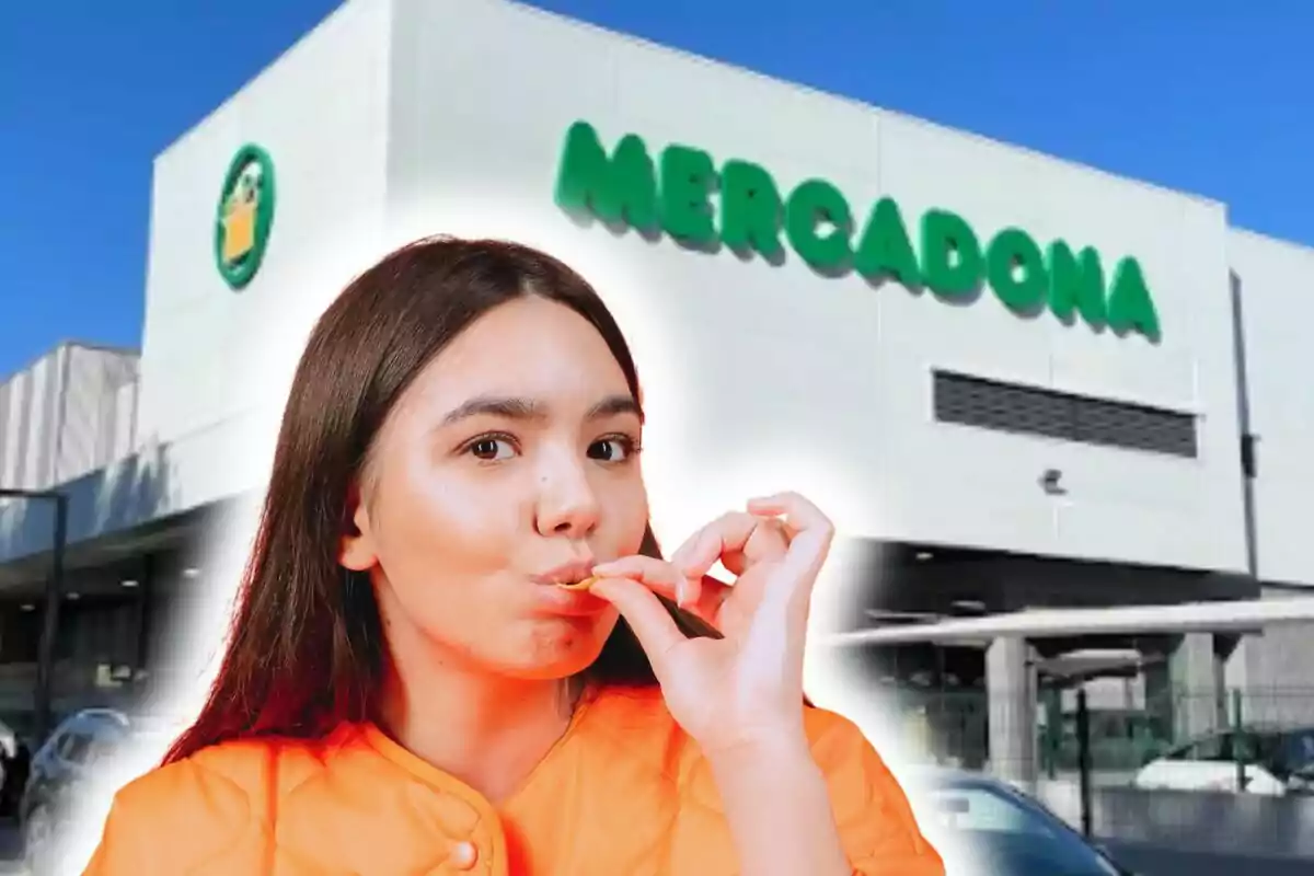 Una persona con una chaqueta naranja está frente a un edificio de Mercadona, llevándose algo de comida a la boca.