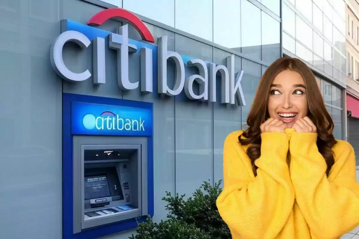 Una mujer sonriente con un suéter amarillo está frente a un cajero automático de un banco.