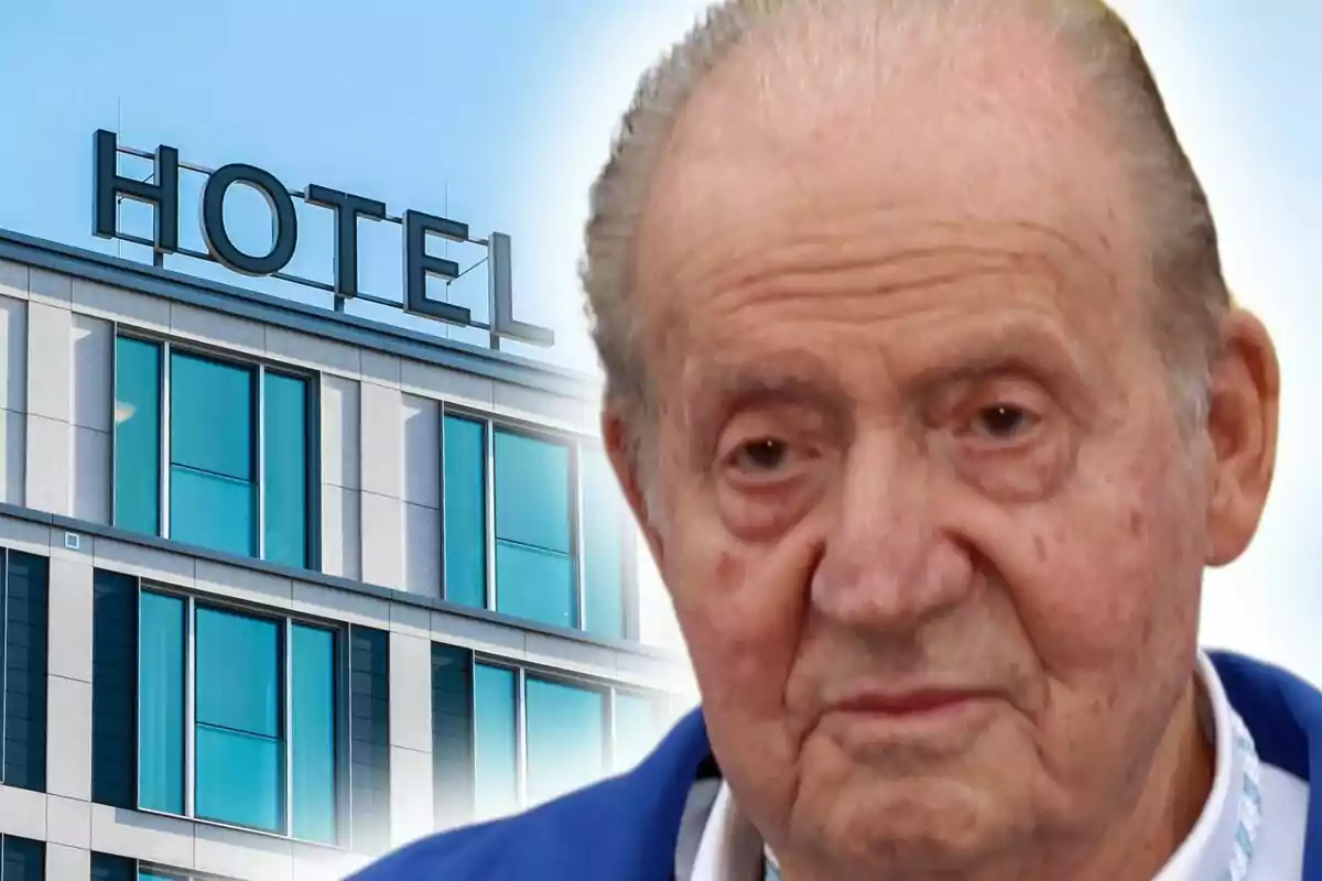 Un hombre mayor, que es Juan Carlos I, con expresión seria frente a un edificio con la palabra "HOTEL" en la parte superior.