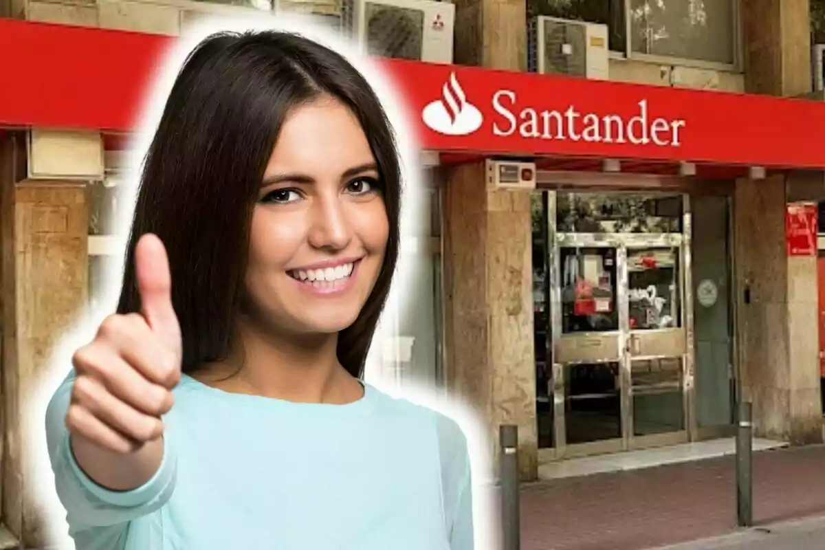 Una mujer sonriente con el pulgar hacia arriba frente a una sucursal del banco Santander.