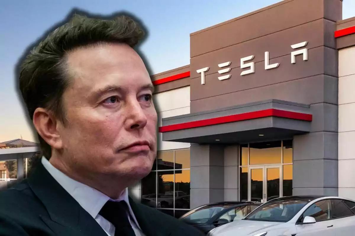 Un hombre con traje oscuro frente a un edificio de Tesla con autos estacionados. Un hombre con traje oscuro frente a un edificio de Tesla con autos estacionados.