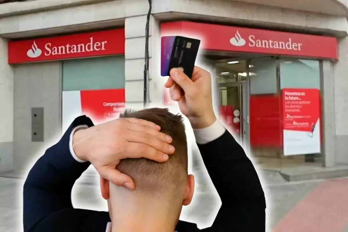 Un hombre de espaldas sostiene una tarjeta de crédito frente a una sucursal del banco Santander.