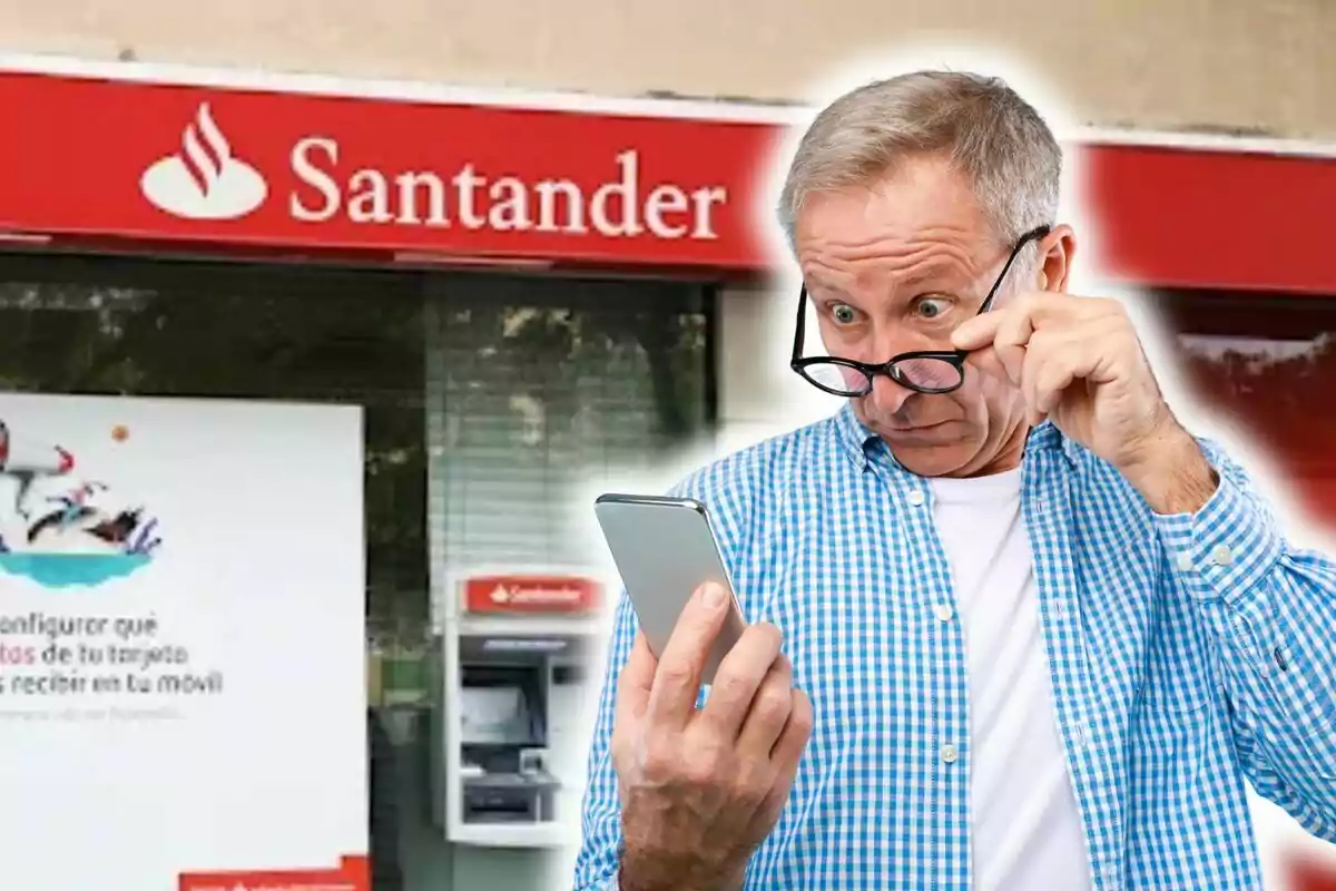 Hombre sorprendido mirando su teléfono frente a una sucursal del Banco Santander.