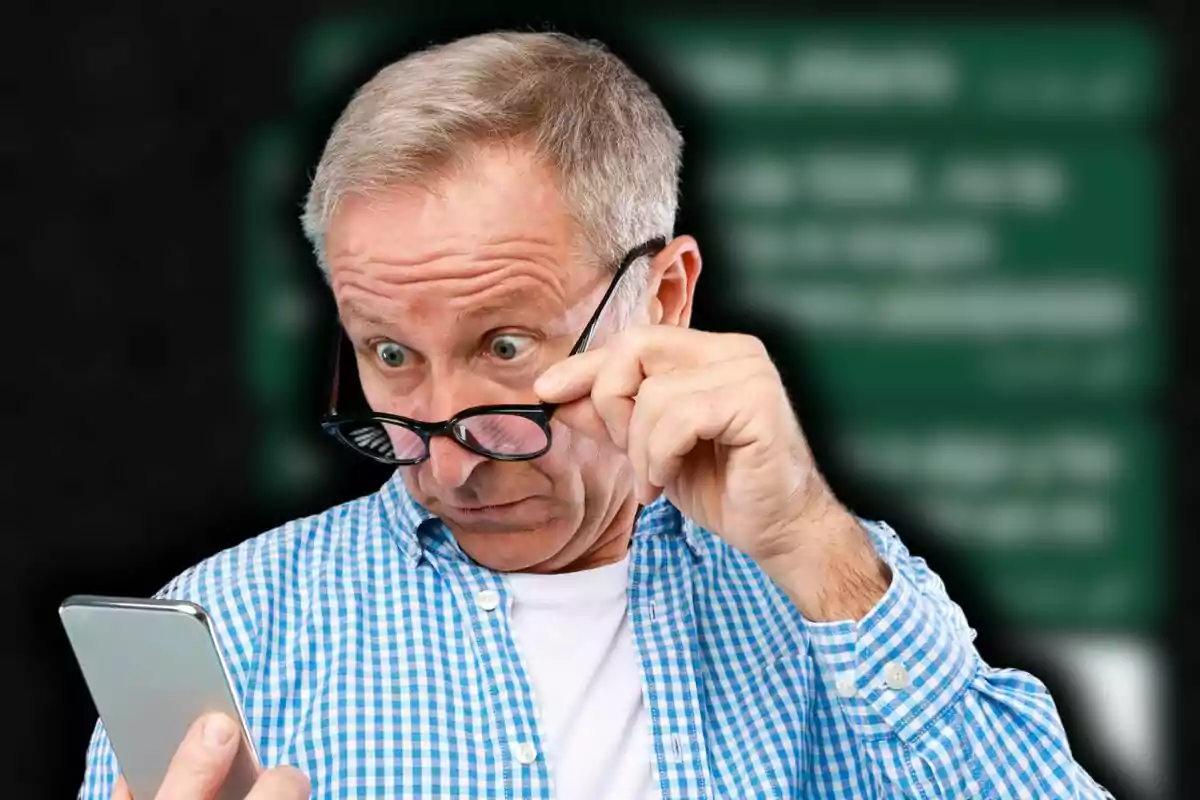 Hombre mayor con camisa a cuadros azules mirando sorprendido su teléfono mientras se ajusta las gafas.