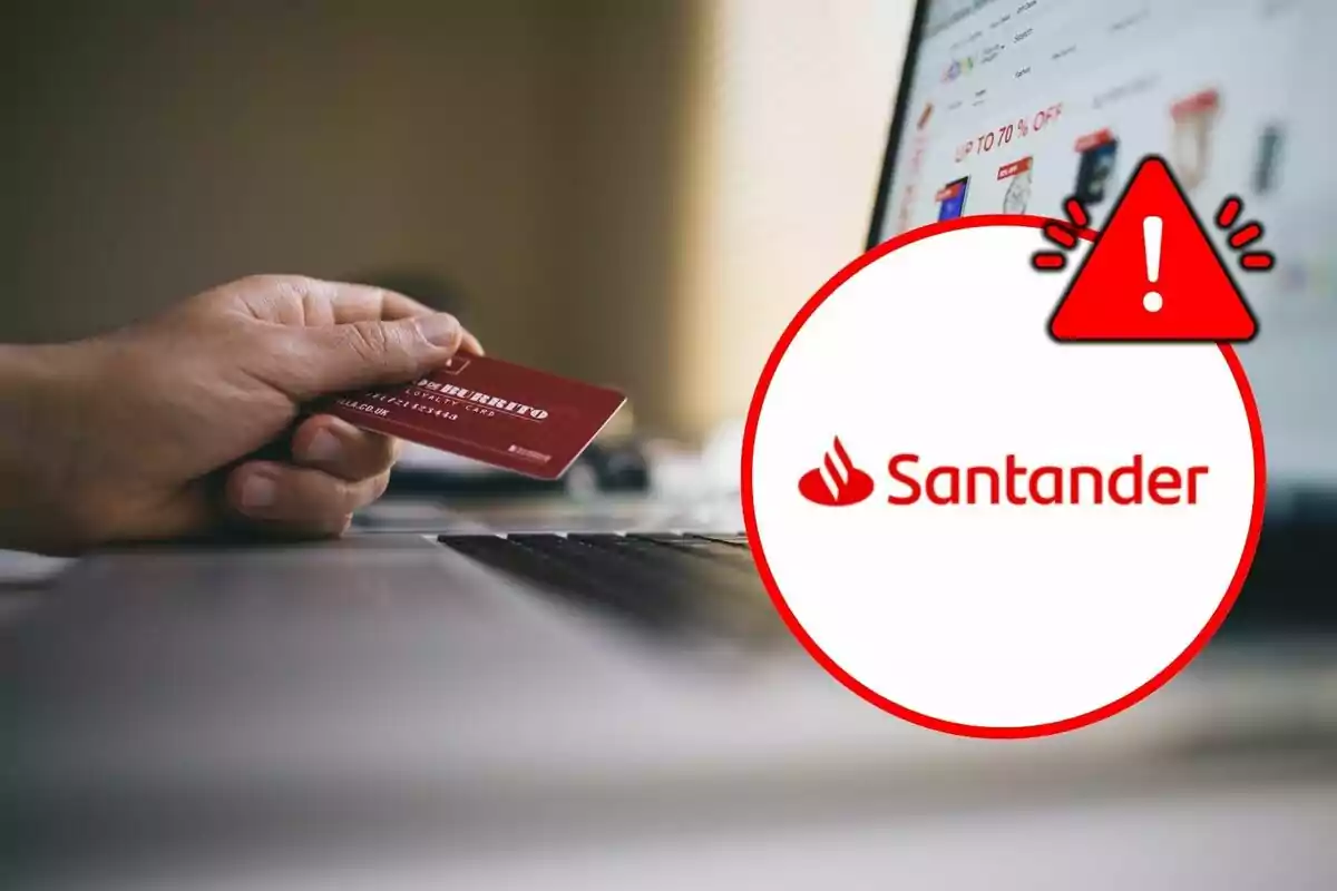 Una mano sosteniendo una tarjeta de crédito frente a una computadora portátil con un logotipo de Santander y un ícono de advertencia.