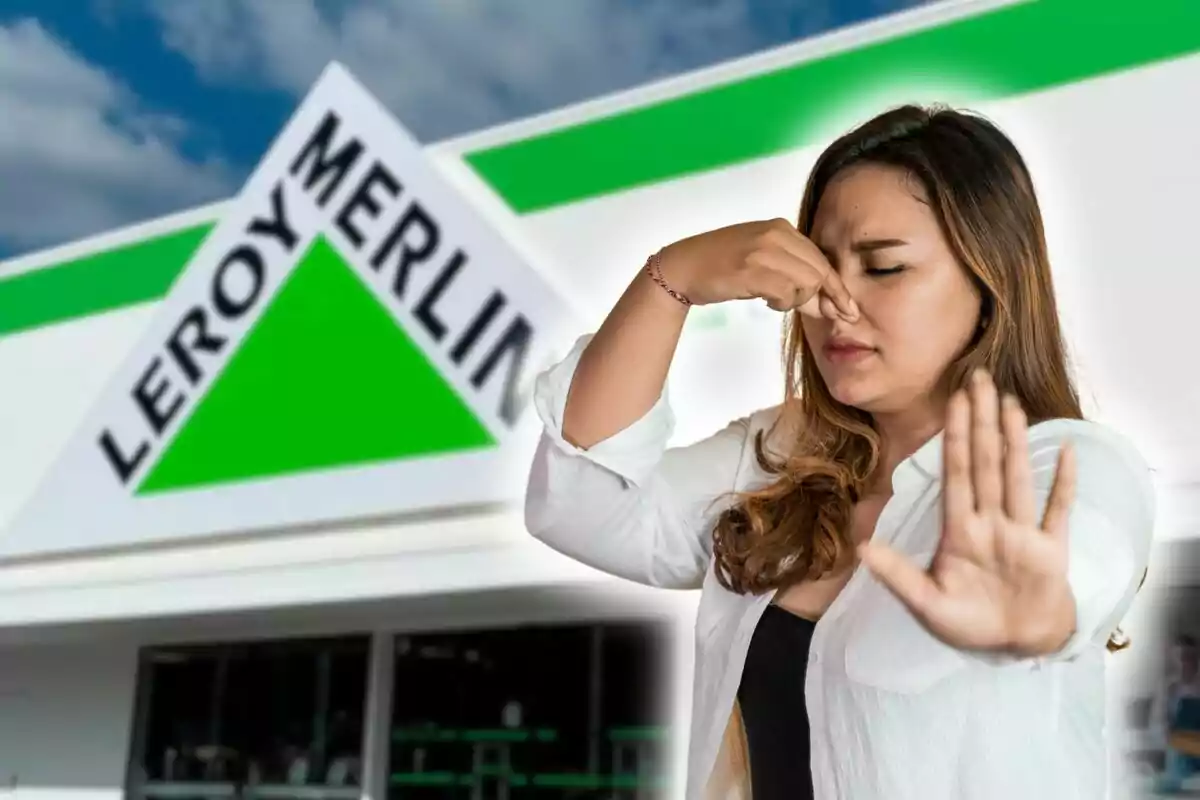 Una mujer se tapa la nariz y levanta la mano frente a una tienda de Leroy Merlin.