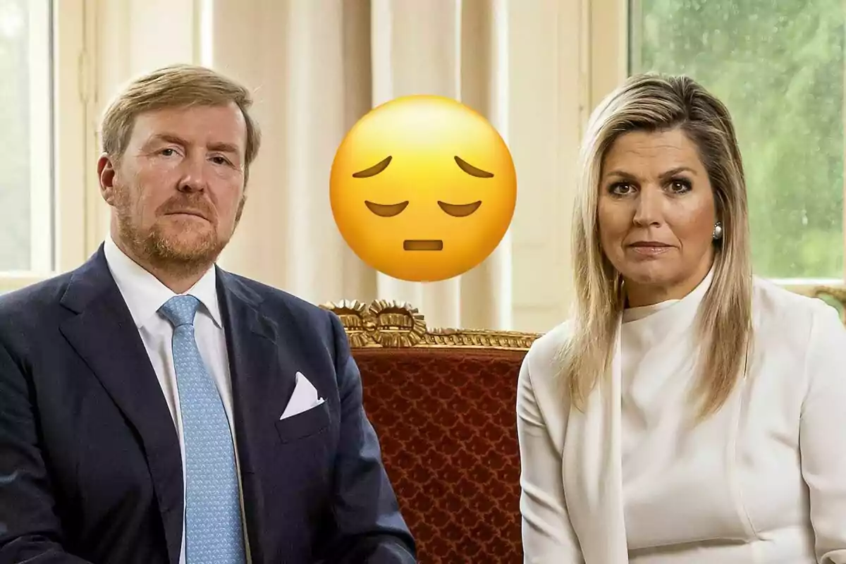 Guillermo y Máxima de Holanda sentada en un sofá elegante con expresión seria y un emoji de tristeza grande entre ellos