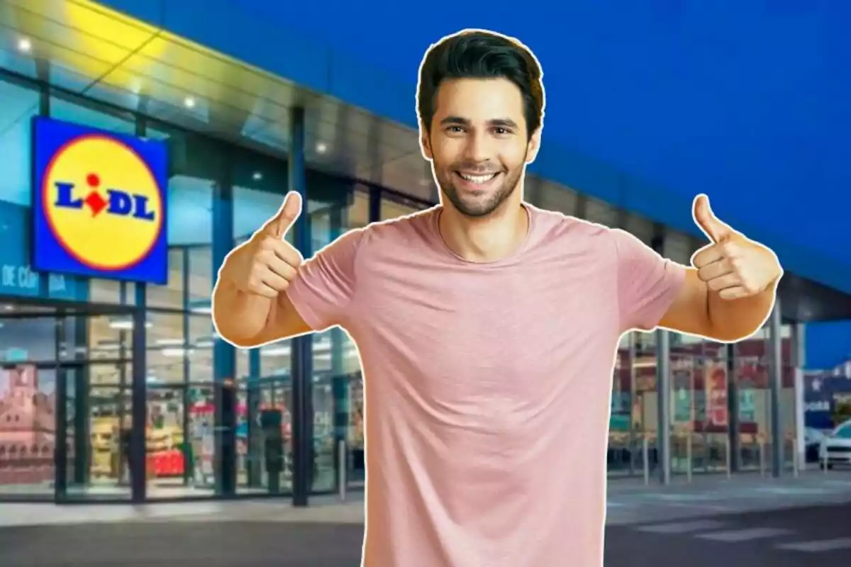 Un hombre sonriente con camiseta rosa hace un gesto de aprobación con ambos pulgares frente a una tienda Lidl iluminada por la noche.