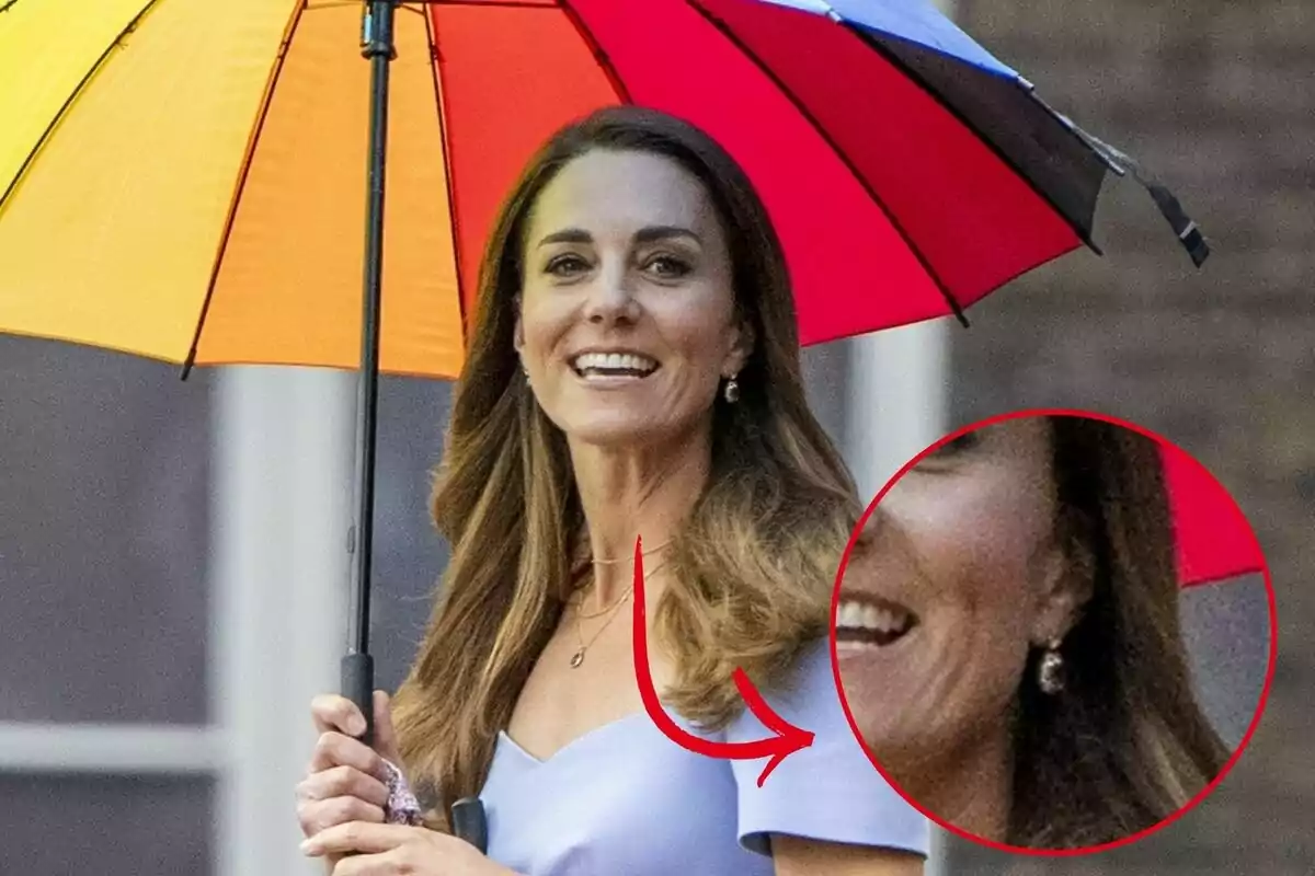 Kate Middleton sonriente sostiene un paraguas de colores brillantes mientras camina al aire libre.