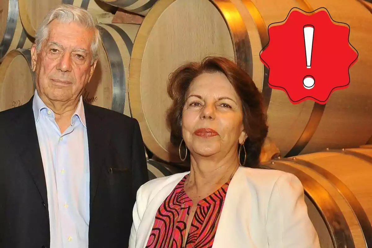 Mario Vargas Llosa y Patricia Llosa posando frente a barriles de madera con un icono de advertencia rojo en la esquina superior derecha.