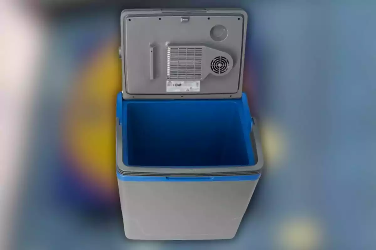 Una nevera portátil gris y azul con la tapa abierta mostrando el interior vacío. Una nevera portátil gris y azul con la tapa abierta mostrando el interior vacío.