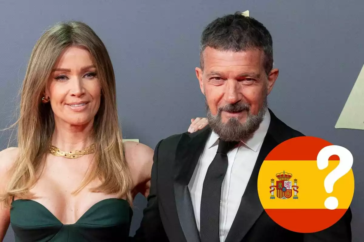 Nicole Kimpel y Antonio Banderas posando en un evento formal con un símbolo de la bandera de España y un signo de interrogación.