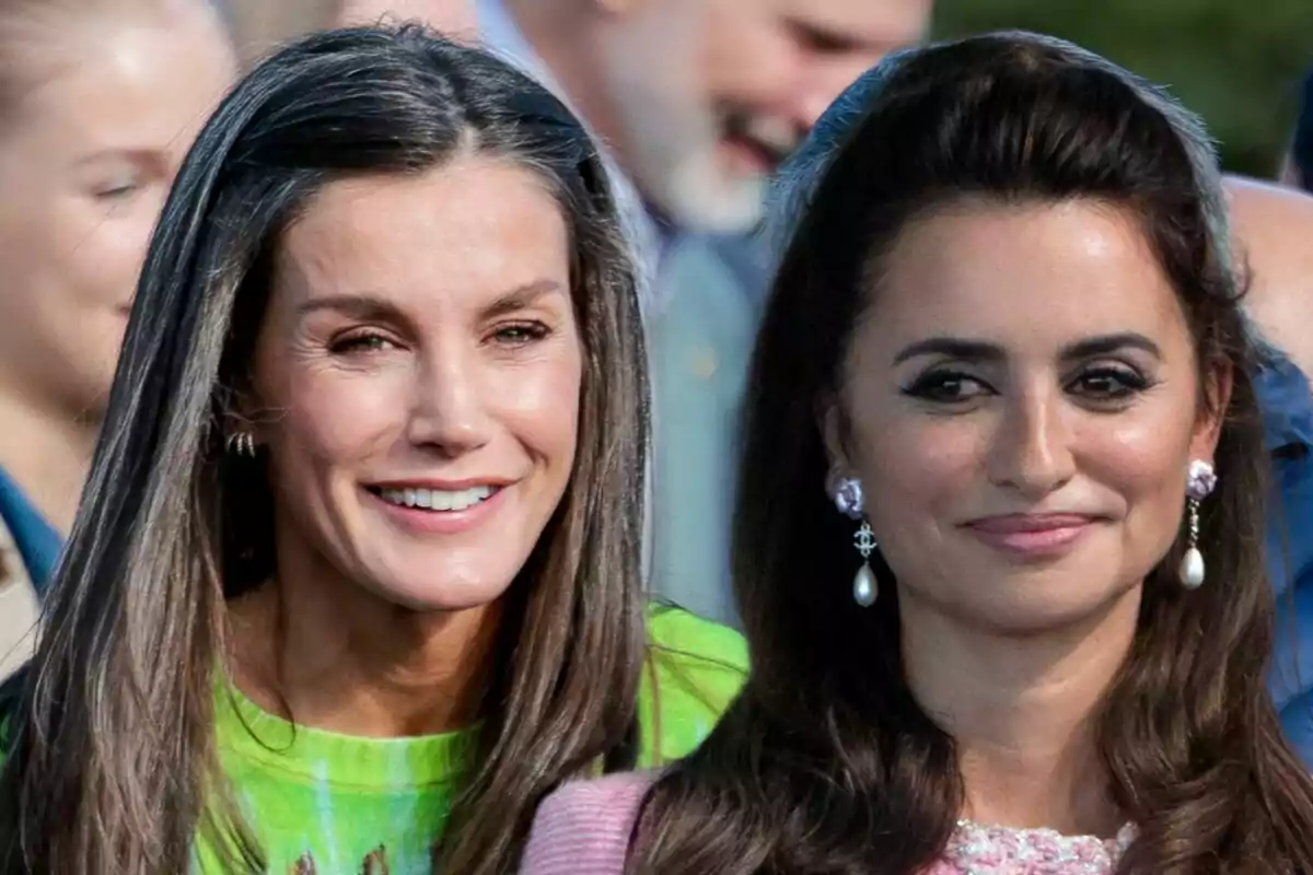 Letizia y Penélope Cruz sonrientes en un evento al aire libre.