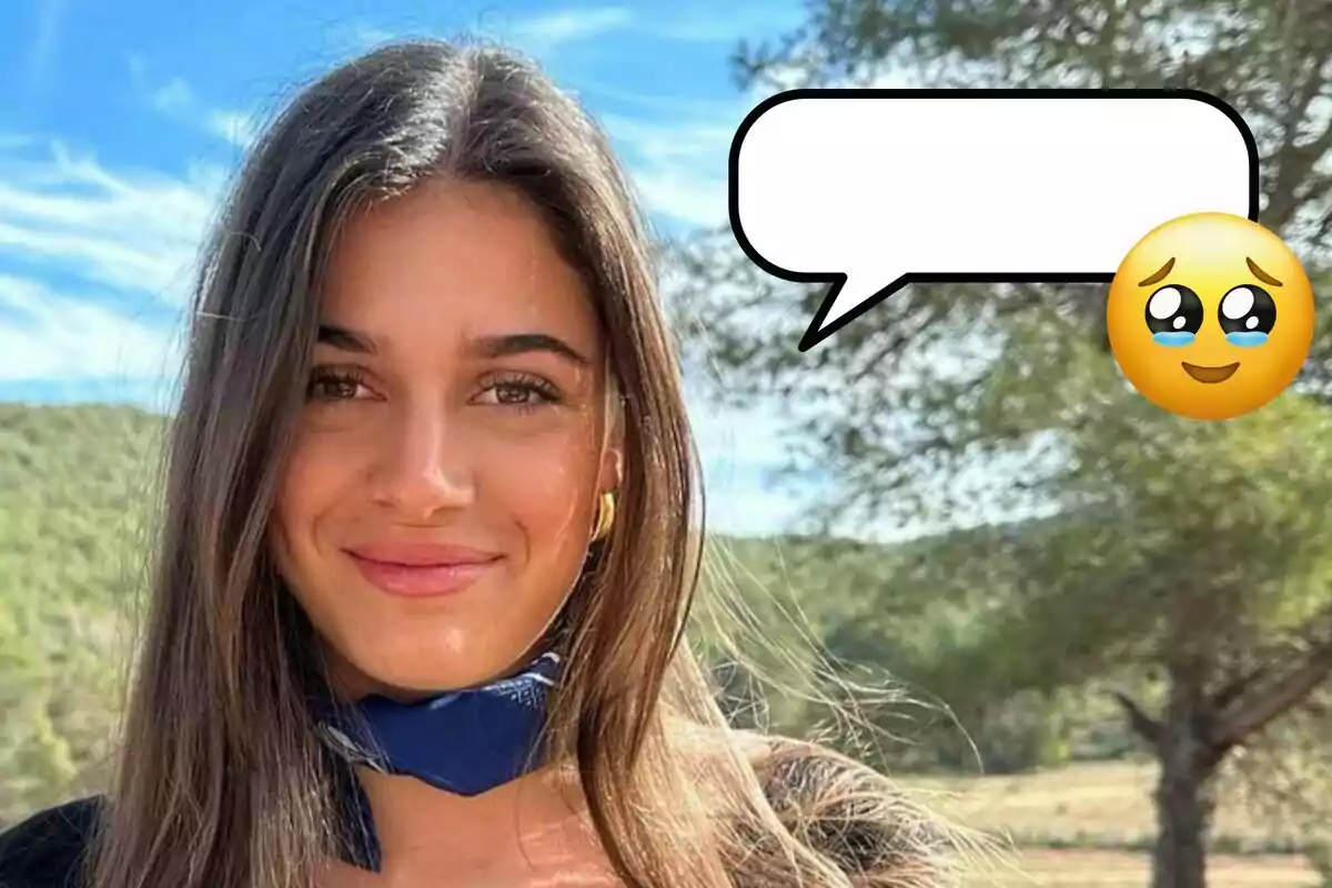 Sira Martínez sonriente con cabello largo y oscuro lleva un pañuelo azul en el cuello y está al aire libre con un paisaje de árboles y cielo azul de fondo. Hay un globo de diálogo vacío y un emoji de carita emocionada.