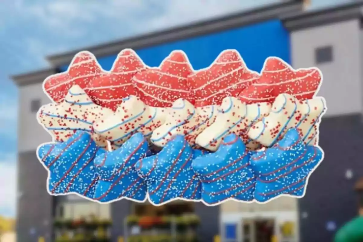 Galletas en forma de estrella decoradas con glaseado rojo blanco y azul con chispas de colores frente a un edificio desenfocado Galletas en forma de estrella decoradas con glaseado rojo blanco y azul con chispas de colores frente a un edificio desenfocado