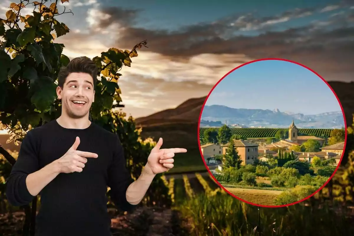 Un hombre sonriente señala hacia una imagen circular de un paisaje rural con montañas, viñedos y edificios, con un cielo parcialmente nublado al fondo.