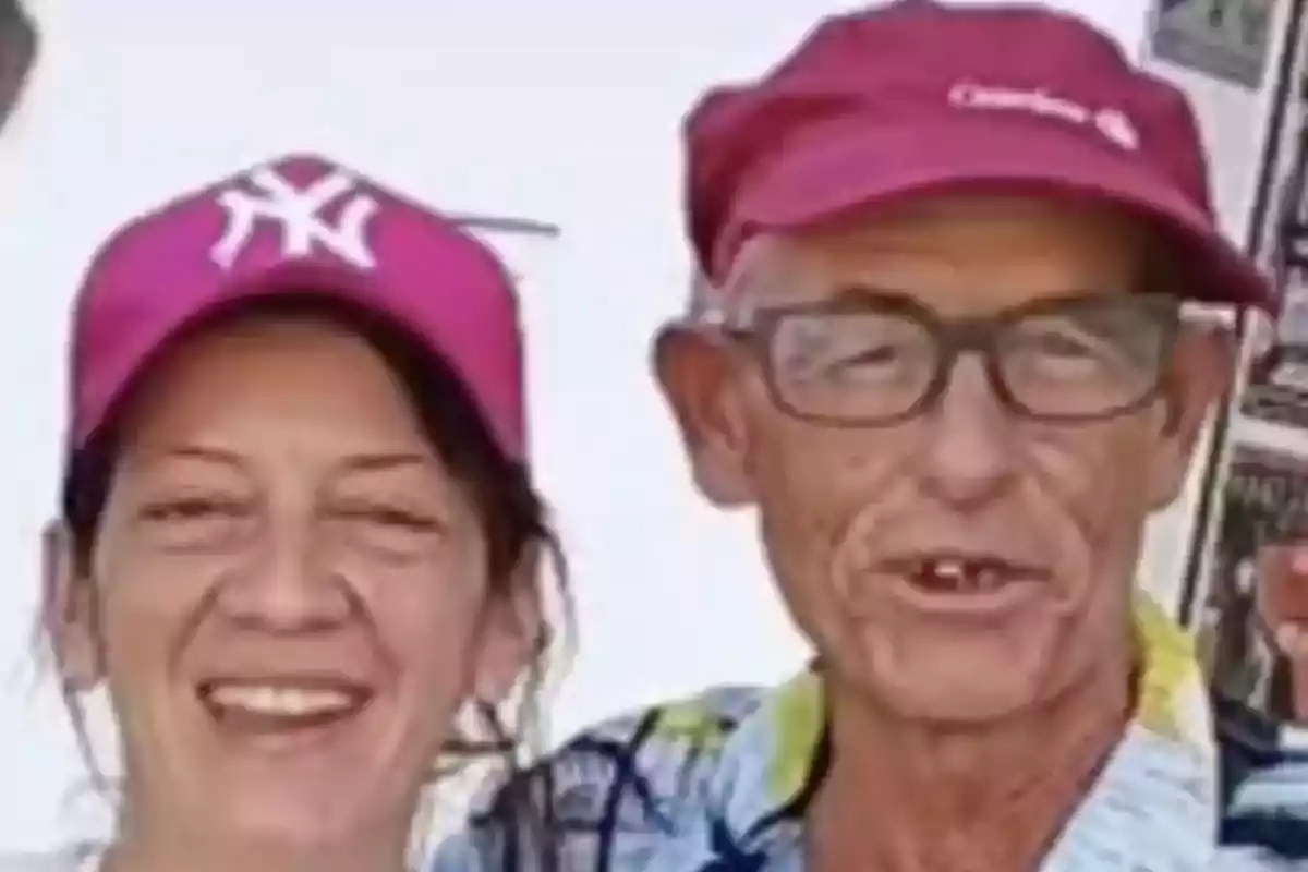 Dos personas sonrientes con gorras rosas.