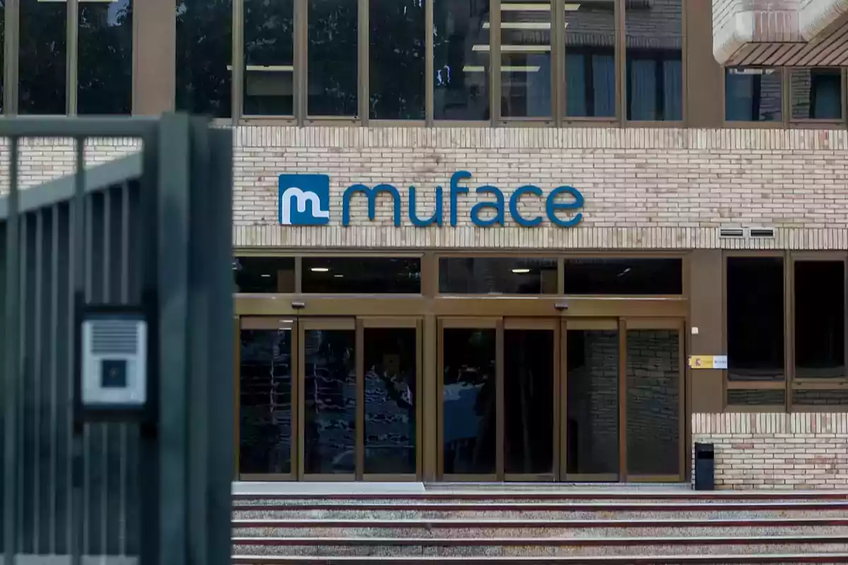 Entrada de un edificio con el logo de Muface en la fachada.