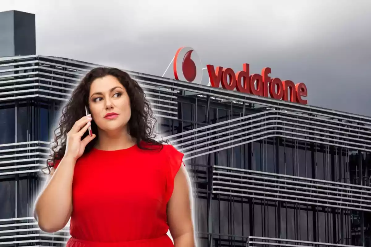 Mujer con vestido rojo hablando por teléfono frente a un edificio de Vodafone.