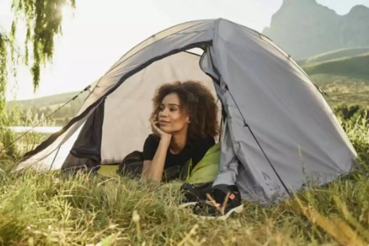 Persona relajándose en una tienda de campaña de Lidl en un entorno natural. Persona relajándose en una tienda de campaña de Lidl en un entorno natural.