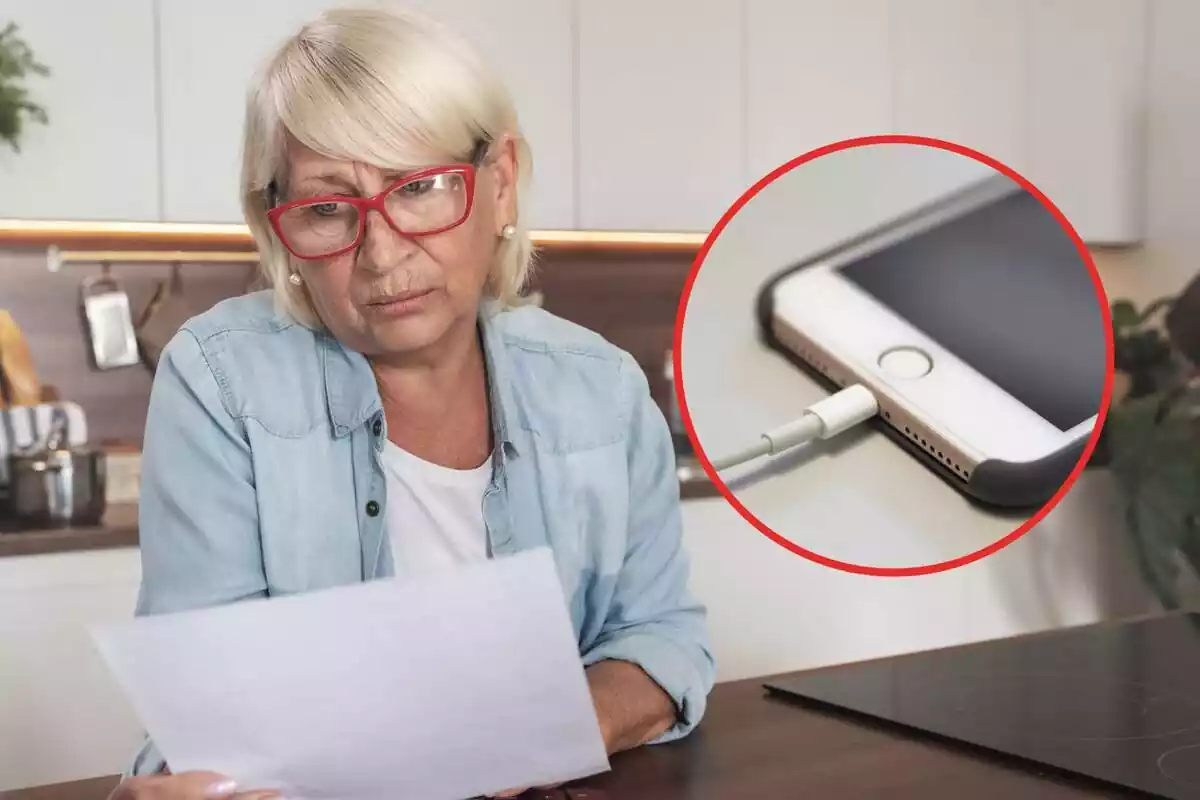 Una mujer mayor viendo su factura de luz y un teléfono móvil enchufado al cargador Una mujer mayor viendo su factura de luz y un teléfono móvil enchufado al cargador