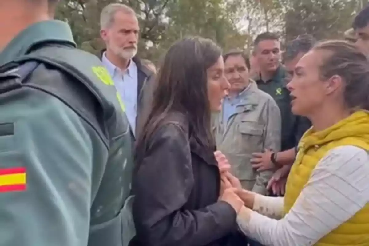 Un grupo de personas interactúa al aire libre, con un guardia civil presente.