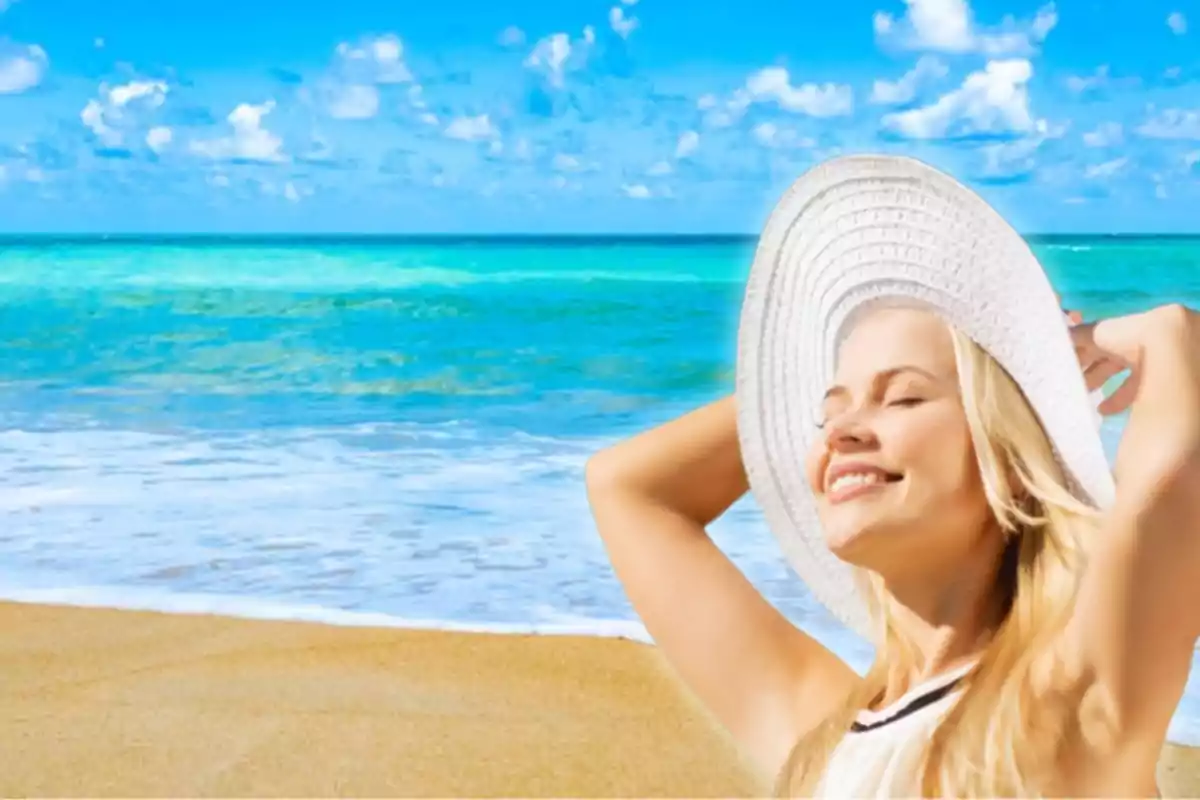 Mujer sonriente con sombrero blanco disfrutando del sol en una playa con mar azul y cielo despejado.