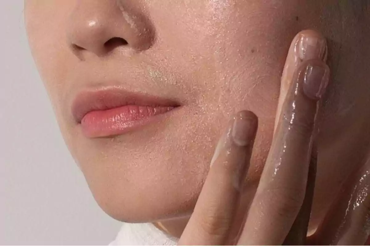 Persona aplicando producto en la piel del rostro.