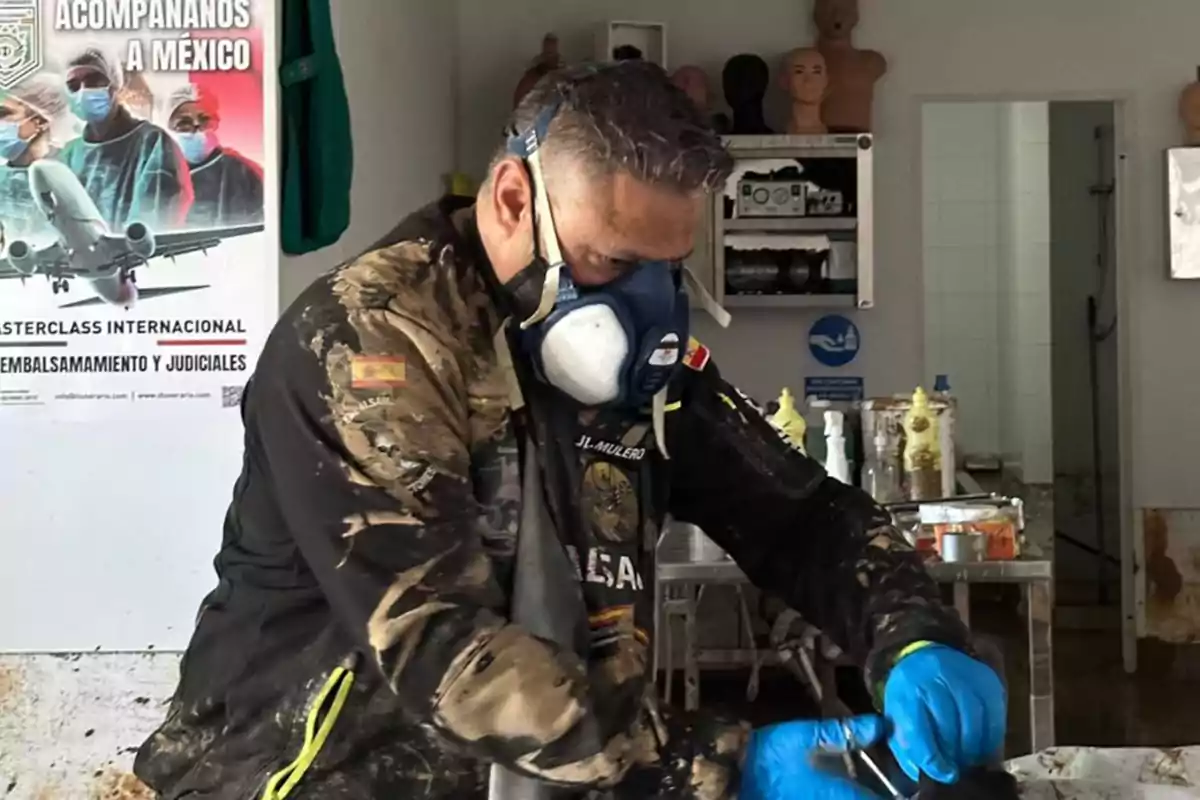 Un hombre con mascarilla y guantes azules trabaja en un laboratorio, con un cartel de fondo que anuncia una masterclass internacional en México.