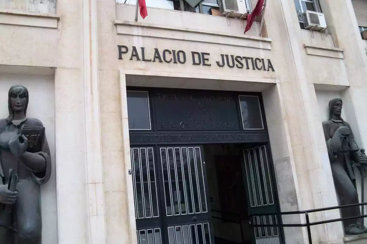 Entrada del Palacio de Justicia con esculturas a los lados y banderas en la parte superior.