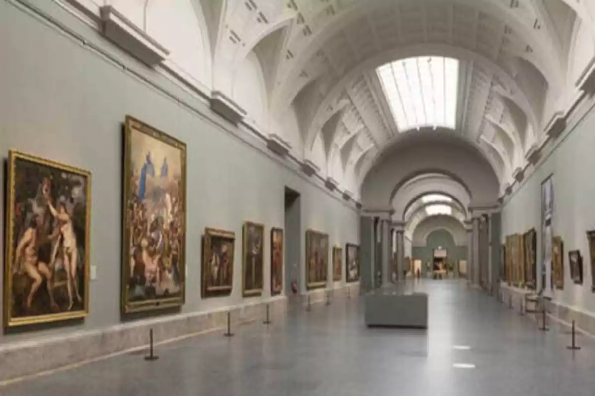 Una galería de arte con pinturas colgadas en las paredes y un techo abovedado.