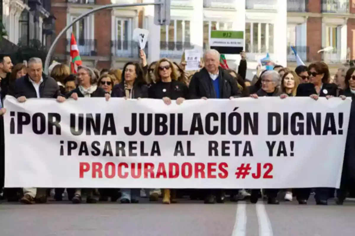 Personas marchando con una pancarta que dice "¡Por una jubilación digna! ¡Pasarela al RETA ya! Procuradores #J2".