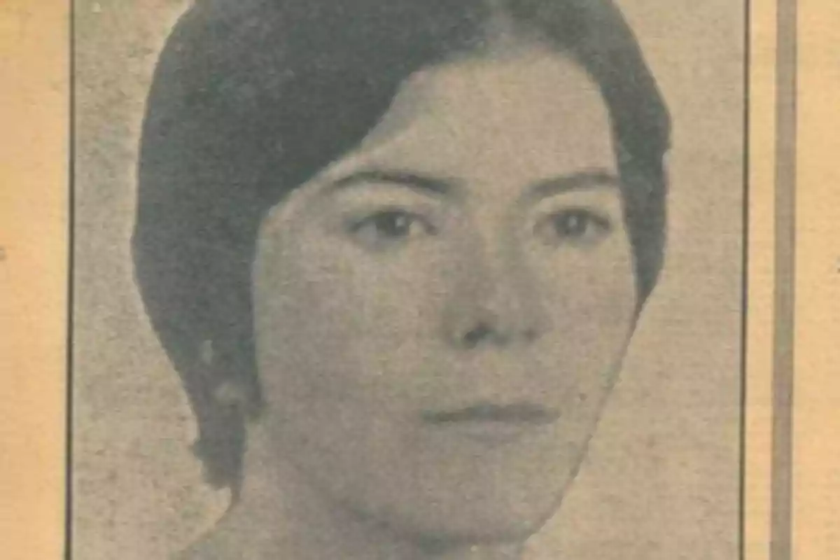 Una fotografía en blanco y negro de una mujer joven con el cabello corto y oscuro, mirando directamente a la cámara, con un fondo de color sepia.