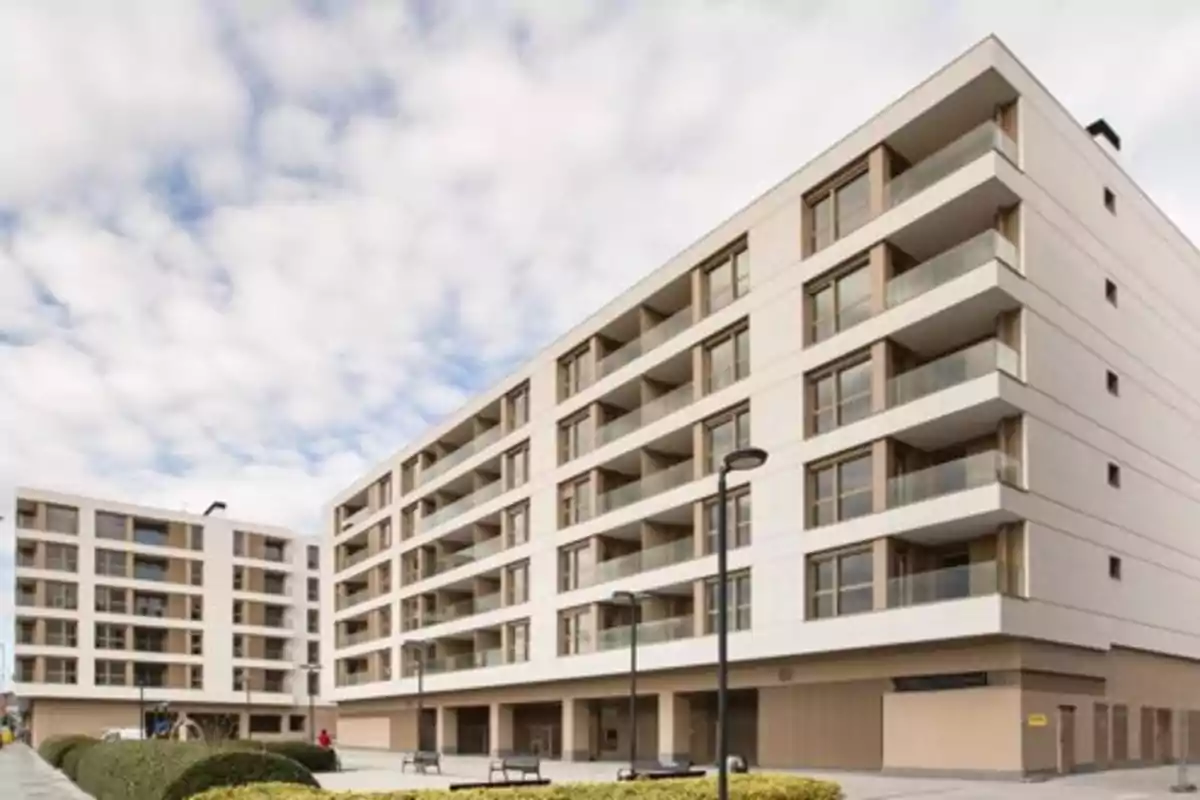 Edificio moderno de departamentos con varias plantas y balcones en una zona residencial