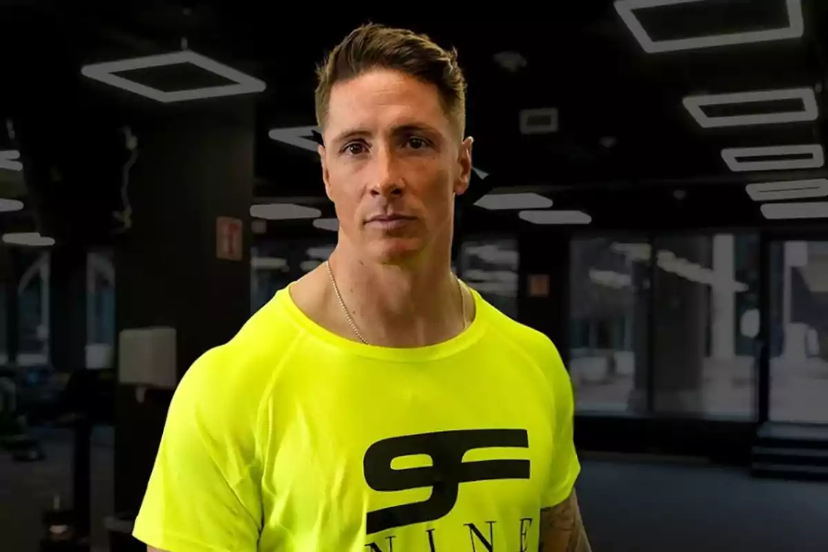 Hombre con camiseta deportiva amarilla posando en un gimnasio moderno Hombre con camiseta deportiva amarilla posando en un gimnasio moderno