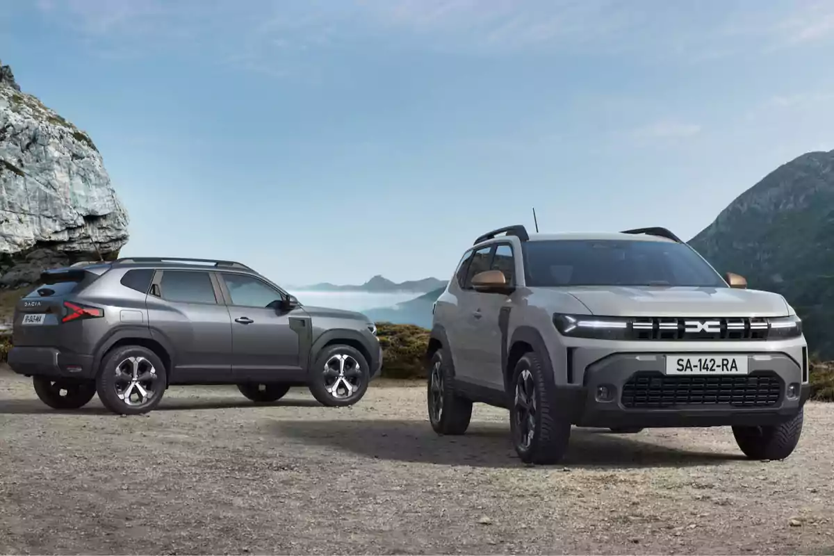 Dos camionetas SUV modernas estacionadas en un paisaje montañoso con cielo despejado Dos camionetas SUV modernas estacionadas en un paisaje montañoso con cielo despejado