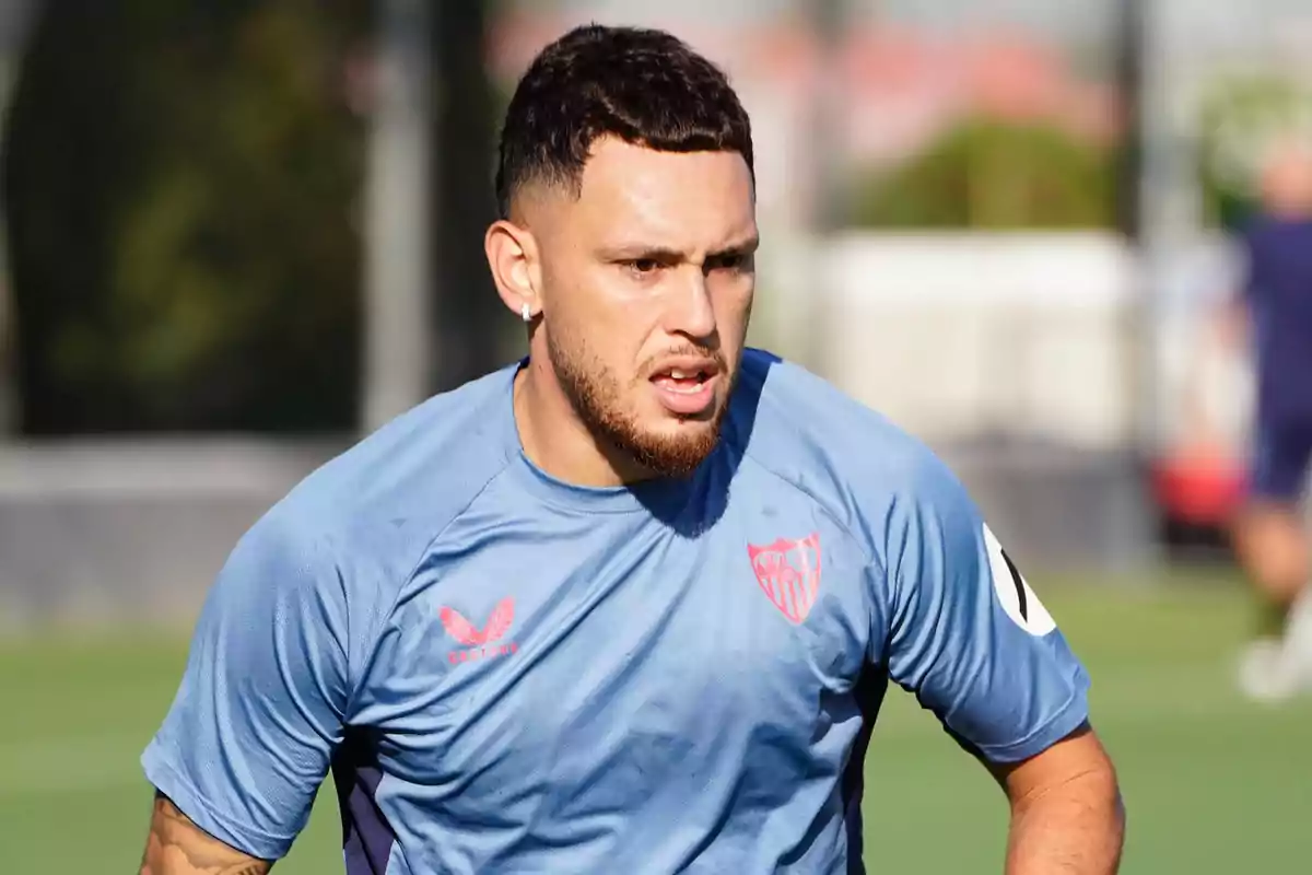 Futbolista entrenando con camiseta azul del Sevilla FC en un campo de fútbol Futbolista entrenando con camiseta azul del Sevilla FC en un campo de fútbol