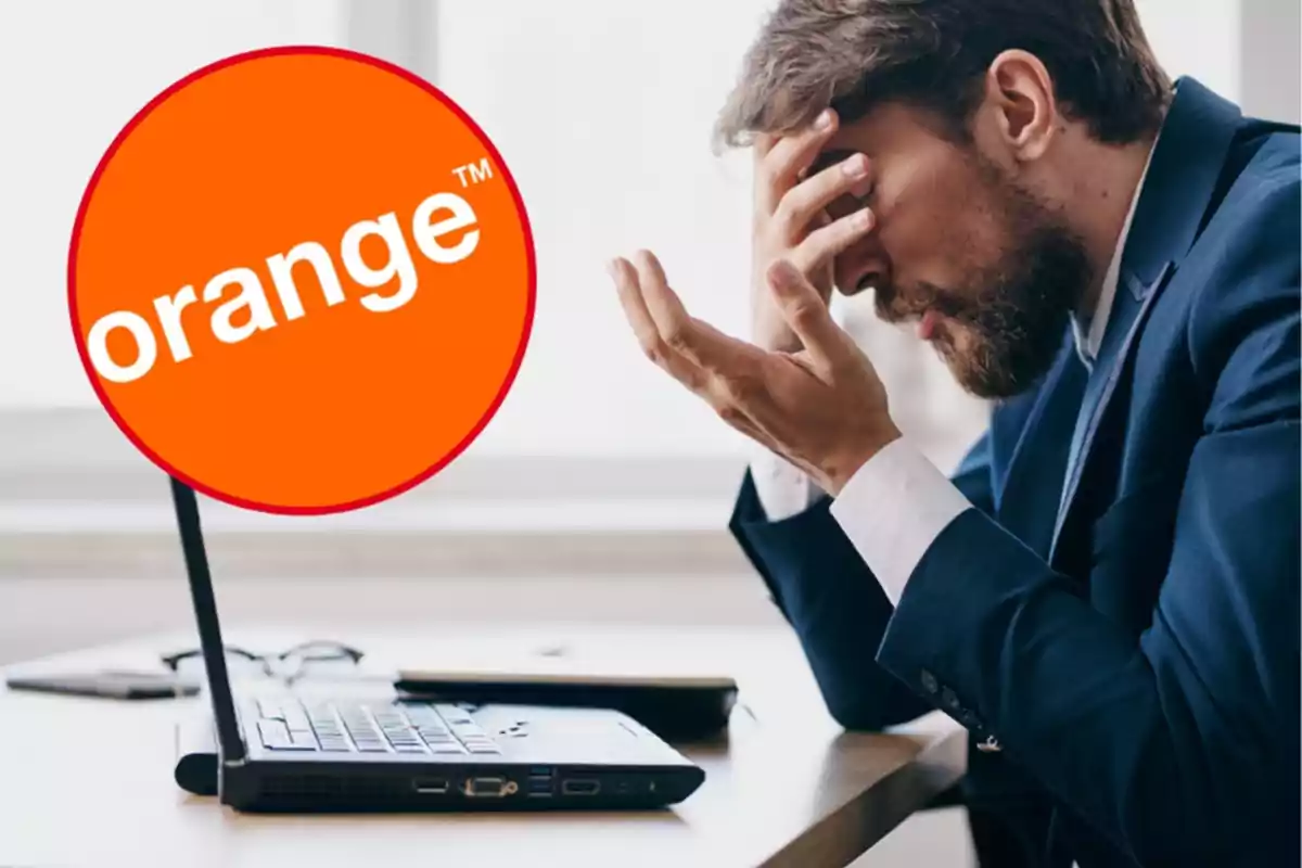 Hombre con traje sentado frente a una computadora portátil, con una mano en la frente y una expresión de frustración, junto a un logotipo de Orange.