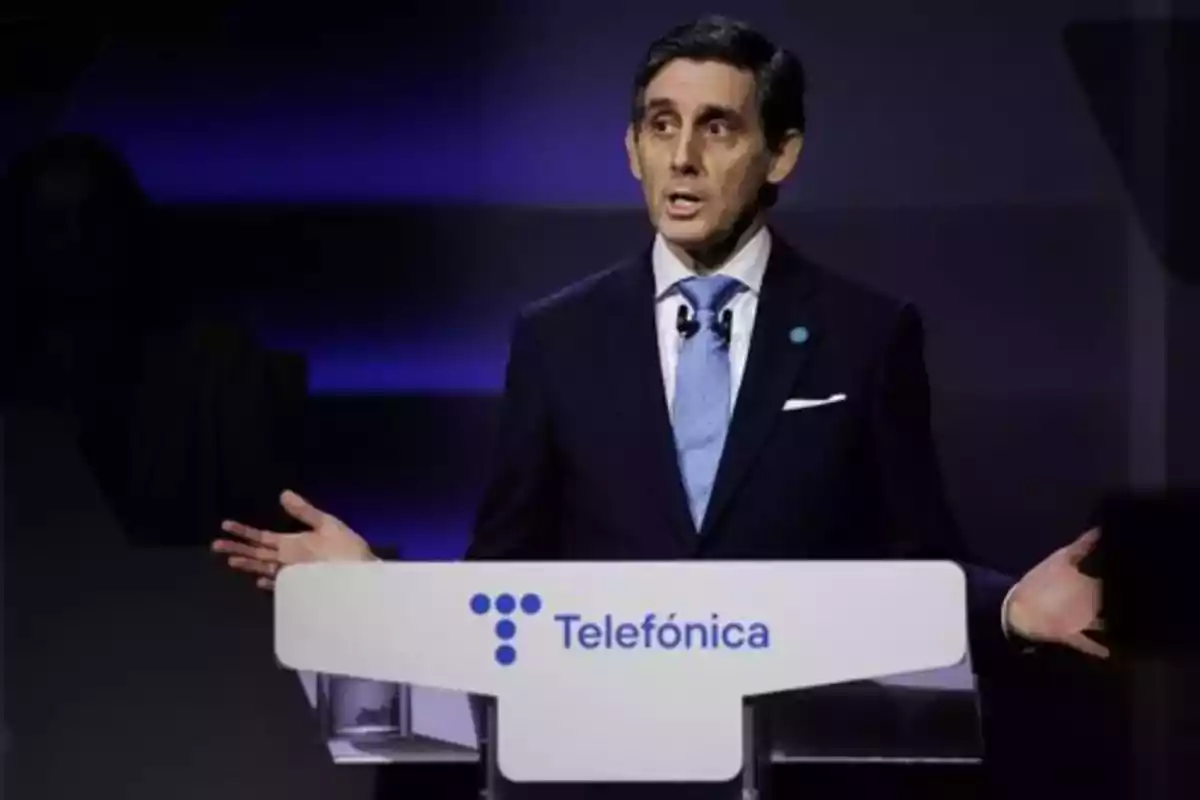 Un hombre en traje hablando en un podio con el logo de Telefónica.