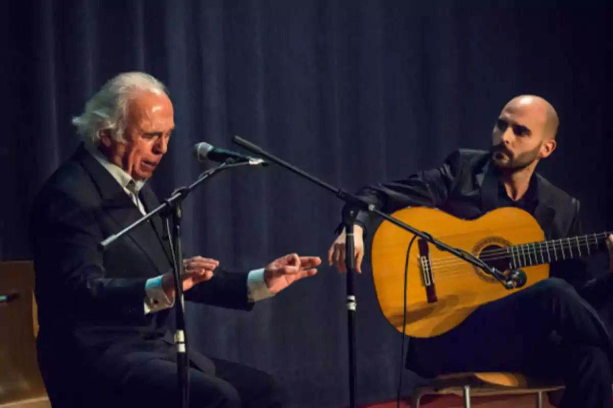 Dos músicos en el escenario, uno cantando y el otro tocando la guitarra.