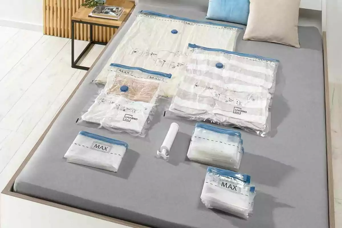 Pack de bolsas de almacenamiento al vacío de Lidl con una bomba manual sobre una cama. Pack de bolsas de almacenamiento al vacío de Lidl con una bomba manual sobre una cama.
